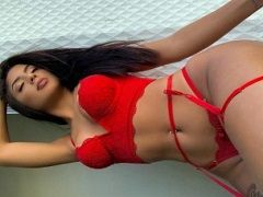 La délicieuse brune En lingerie rouge montrant ses seins