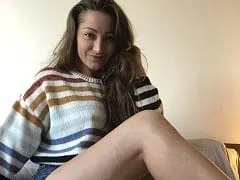 Délicieuse actrice porno du Royaume-Uni à quatre pattes sur le canapé, roulant son cul et montrant sa chatte.